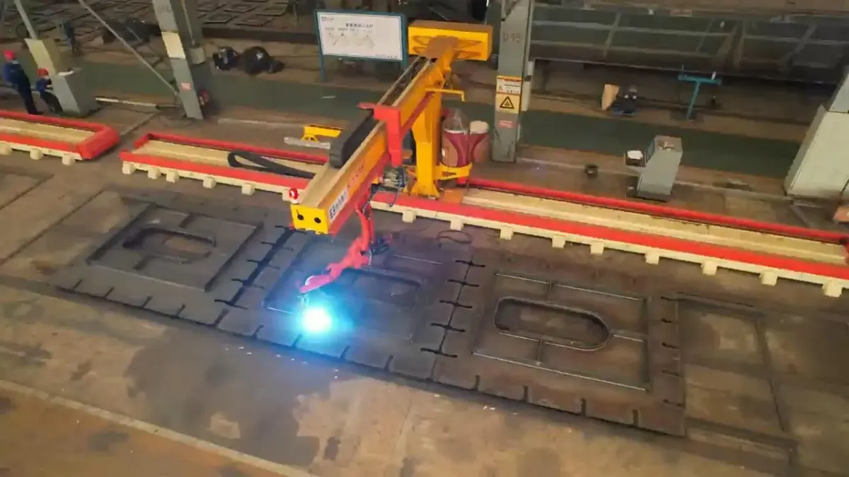 Estación de soldadura en voladizo sobre un panel de acero, con el arco de soldadura visible.