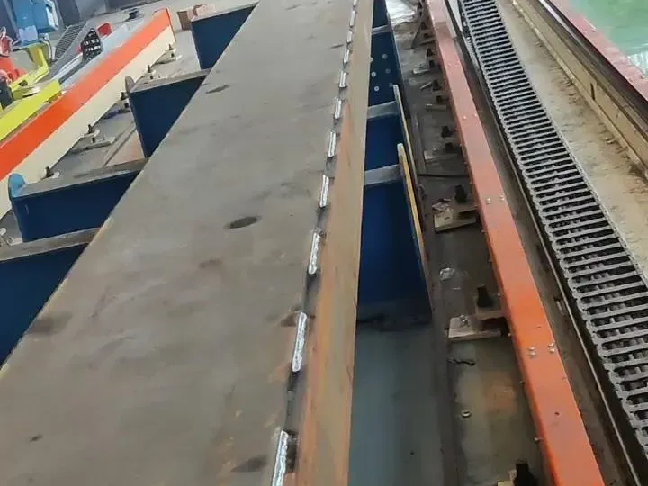 Long steel beam with a row of short intermittent fillet welds beside the rail.