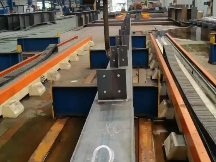 H-beam on a welding station with purlin cleats welded along the flange.