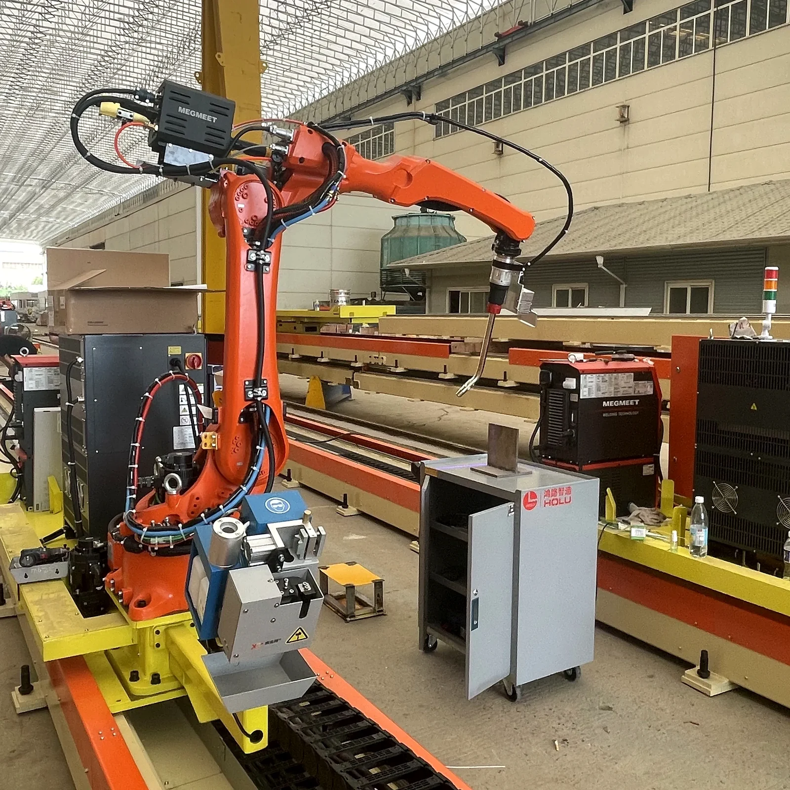 Rail-mounted welding robot system with torch service equipment and control cabinets