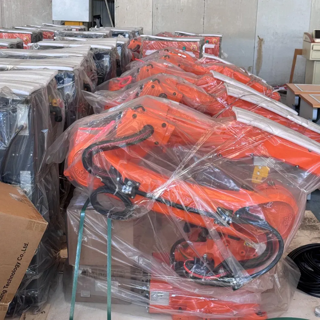 Orange welding robots wrapped in protective film and packed for shipment.
